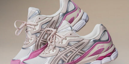 Pair of pink and beige running shoes on a neutral background
