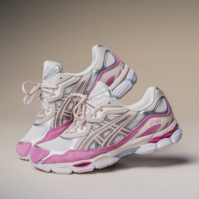 Pair of pink and beige running shoes on a neutral background