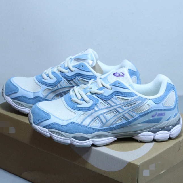 White and blue sneakers with mesh detailing on a brown cardboard box.