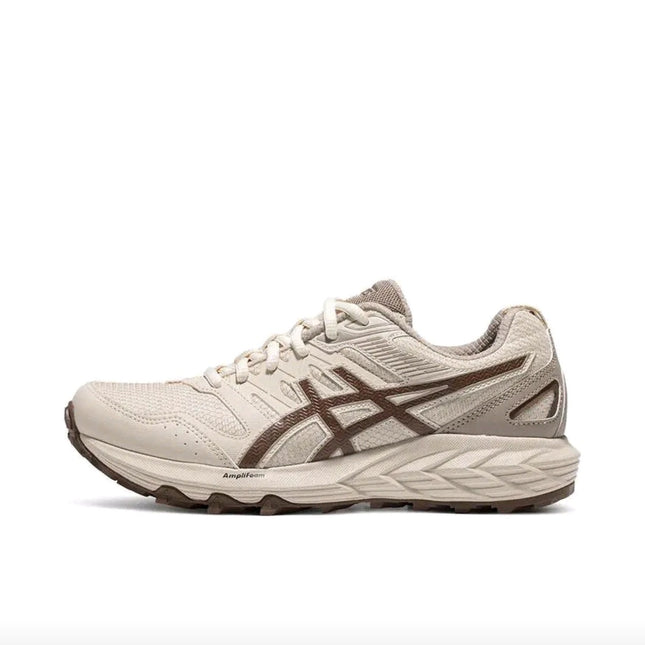 Beige running shoe with brown accents, textured sole, and mesh upper, side view.