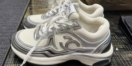 White sneakers with a logo on a glass table