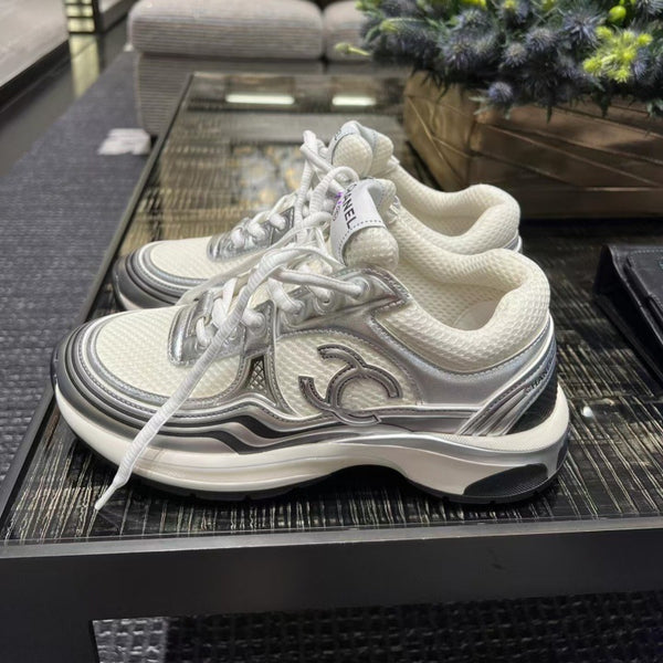 White sneakers with a logo on a glass table