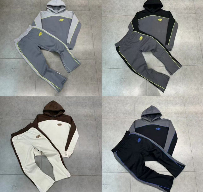 Four different color options of a hoodie and pants set on a tiled floor.