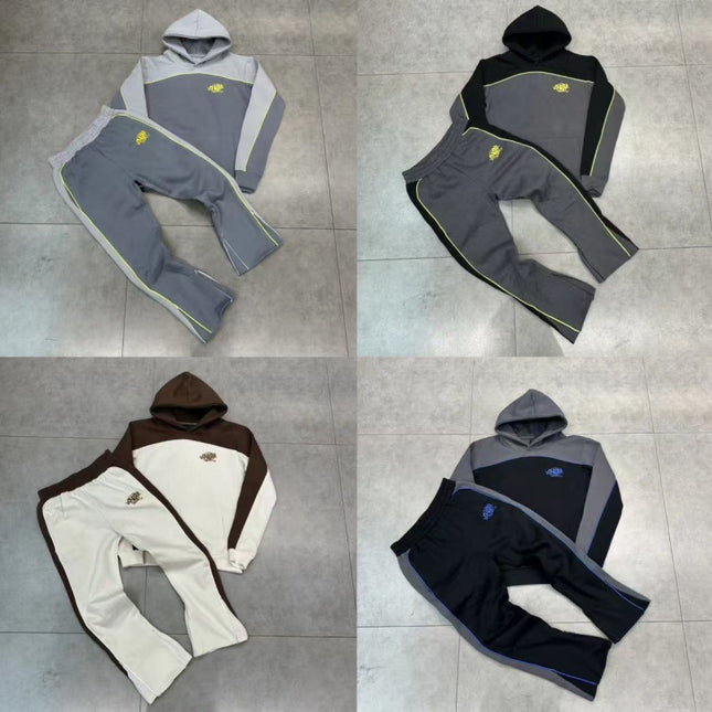 Four different color options of a hoodie and pants set on a tiled floor.