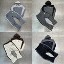 Four different color options of a hoodie and pants set on a tiled floor.