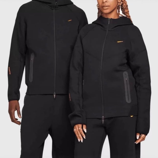 Two people wearing matching black outfits with a brand logo on a white background