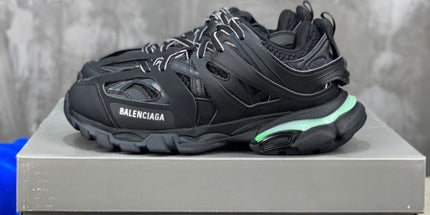 Black Balenciaga sneaker on a gray platform with a blurred background