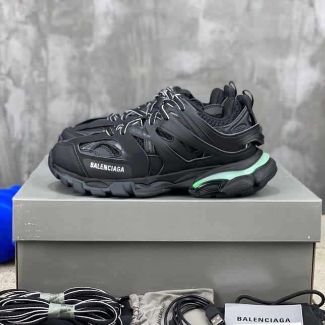Black Balenciaga sneaker on a gray platform with a blurred background