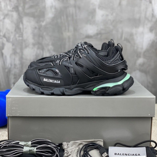 Black Balenciaga sneaker on a gray platform with a blurred background