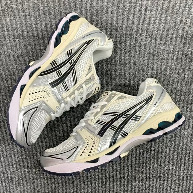 Silver athletic shoes with black stripes on a gray textured surface.