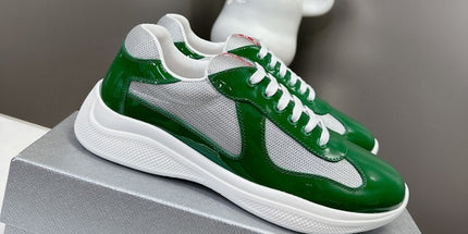 Green and white sneakers on a gray box with a blurred white object in the background