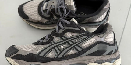 Gray and black athletic shoes with mesh fabric, thick soles, and intricate side patterns.