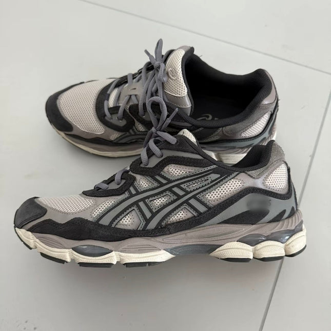Gray and black athletic shoes with mesh fabric, thick soles, and intricate side patterns.
