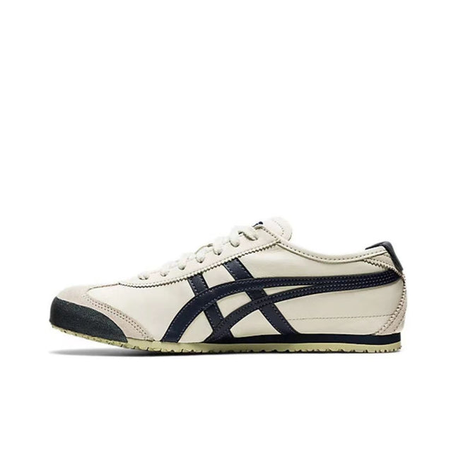 Cream sneaker with navy stripes, beige sole, and black toe cap, side view.
